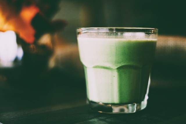 Green smoothie in a clear glass by Fallon Michael on Unsplash.