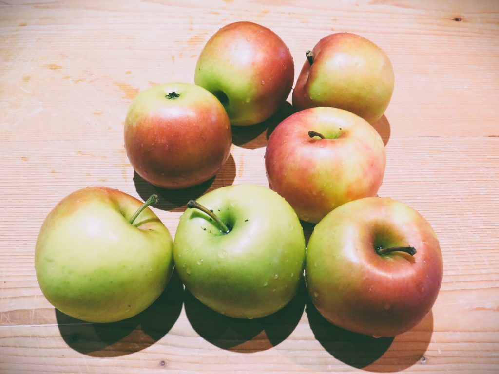 Several apples on a wood board by Crystal Smith.
