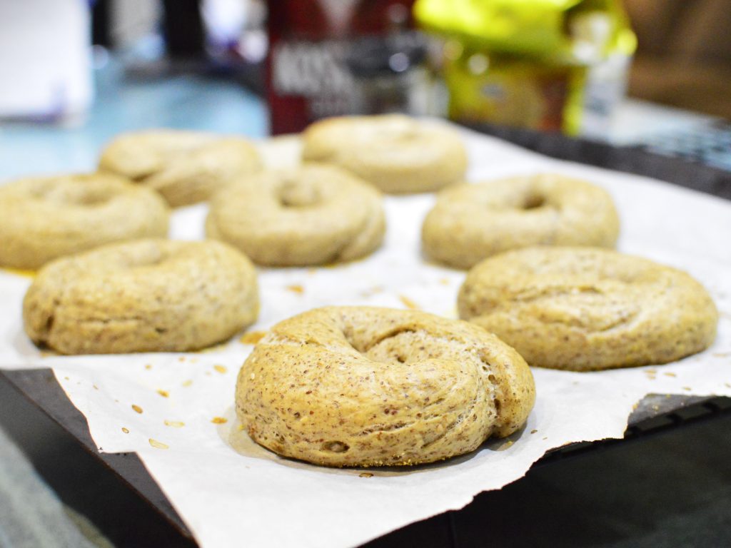 Freshly baked bagels on a baking sheet lined with parchment.