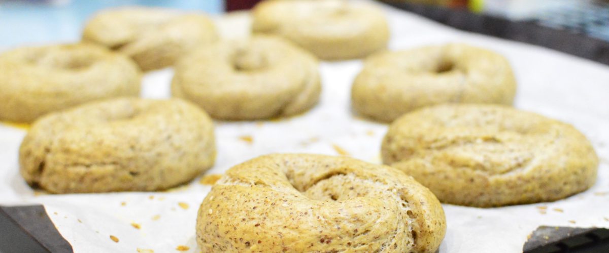 Freshly baked bagels on a baking sheet lined with parchment.