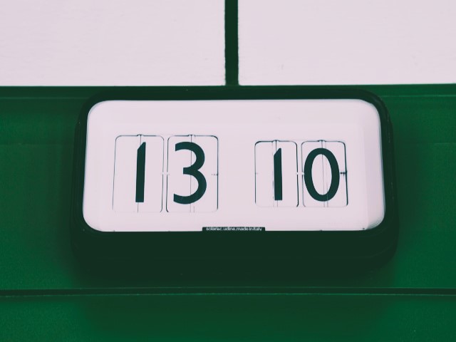 Retro digital clock on a green background using 24-hour clock by Prometheus on Unsplash.