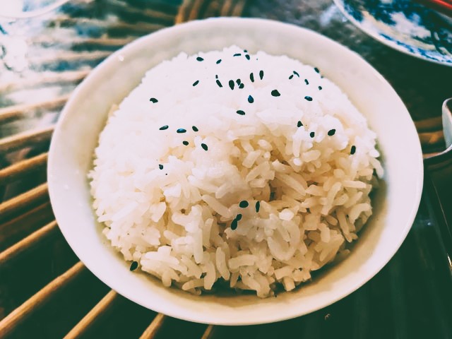 Bowl of white rice with black sesame seeds on top by Markus Winkler on Unsplash.